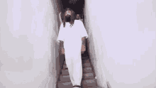a man in a white shirt is standing in a room with smoke coming out of it .