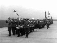 a black and white photo of a marching band with a flag that says o on it