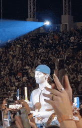 a man with white paint on his face is being photographed by a crowd