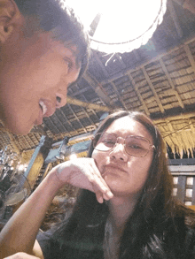 a man and a woman are looking at each other with the man sticking his tongue out