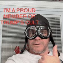 a man wearing a helmet and goggles giving a thumbs up sign