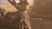 a blurred image of a person holding a sword in a desert .