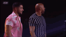two men standing next to each other with the aew logo on the bottom
