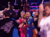 a group of people are dancing in a dark room with a man wearing a shirt that says ' a ' on the back