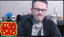 a man wearing glasses and a shirt that says star wars on it