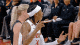 a female basketball player wearing a white headband with the number 20 on it