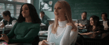 two girls sit in a classroom looking up at the sky