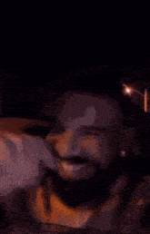 a man with a beard is smiling in a car .