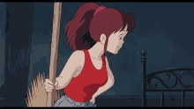 a woman in a red tank top is holding a broom and smiling