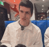 a young man wearing a white shirt and black gloves
