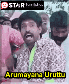 a man with a mustache stands in front of a crowd and says " arumana uruttu "