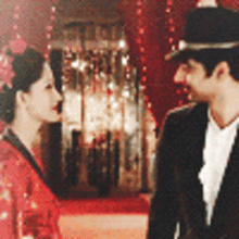 a man in a suit and a woman in a red kimono are looking at each other