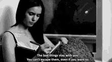 a black and white photo of a woman writing in a notebook with a quote that says the bad things stay with you .