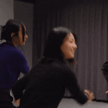 a woman in a black turtleneck is dancing with her arms in the air