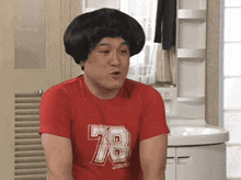 a man wearing a red shirt that says 78 on it