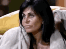 a woman is sitting on a couch with her head resting on her hand .