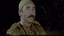 a man with a mustache is wearing a military uniform with a red collar