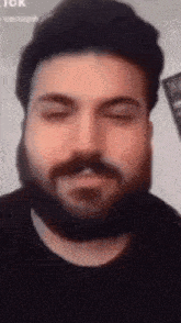 a man with a beard is making a funny face .