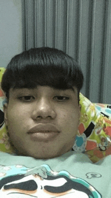 a young man is laying on a bed wearing a shirt with a cartoon character on it .