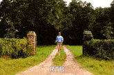 a man is running down a dirt road with the words `` rtb '' written on the side .