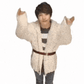 a man wearing a white sweater and a red belt