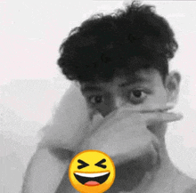 a man is covering his face with his hand and there is a smiley face in the corner .