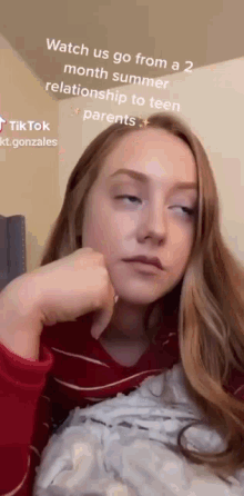 a girl is laying in bed with her eyes closed and a tiktok written on the bottom of her face .