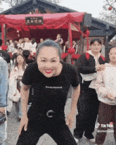a woman wearing a black shirt that says " you are blooming "