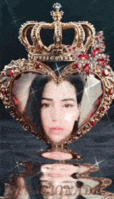 a woman is sitting in a heart shaped frame with a crown on her head .