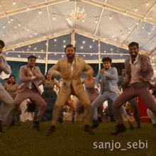 a group of men in suits are dancing under a tent with the name sanjo_sebi on the bottom right