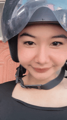 a woman wearing a black helmet is smiling for the camera