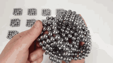 a person is holding a bunch of metal beads in their hands