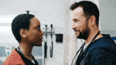 a man and a woman are standing next to each other in a hospital room .