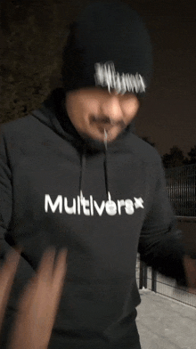 a man wearing a black multiverse hoodie and a black beanie