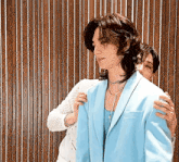 a woman is hugging a man in a blue jacket