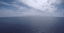 a large body of water with a blue sky and clouds