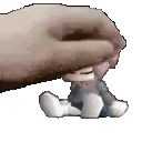 a hand is holding a small stuffed animal over a small doll .