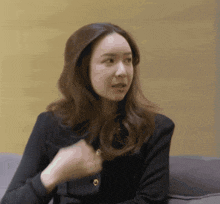 a woman in a black shirt has a gold button on her sleeve