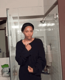a woman in a black sweater stands in front of a shower