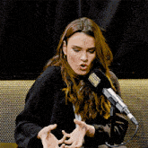 a woman speaking into a microphone that has the word broadway on it