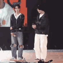 two men are standing on a stage with army written on the screen behind them