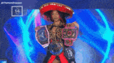 a woman wearing a sombrero is holding a belt that says queen on it