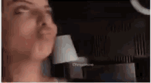 a woman is making a funny face in front of a mirror in a dark room .