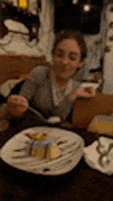 a woman is sitting at a table with a plate of food on it .