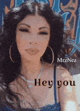a woman wearing hoop earrings and a necklace with the words hey you on the bottom