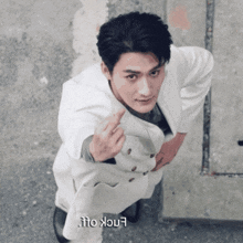 a man in a white suit giving the middle finger with the word enock on the bottom
