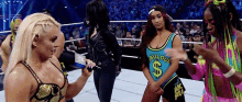a group of women are standing in a wrestling ring . one of the women is wearing a shirt that says gorgeous