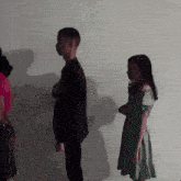 a man in a suit and a woman in a green dress are standing next to each other