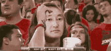 a pixelated image of a woman sitting in a stadium watching a game between sony and m soft