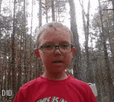 a young boy wearing glasses and a red shirt that says this is us